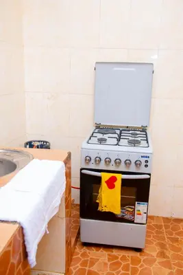 a kitchen with a stove with a towel on the door at Mella home Arusha in Arusha