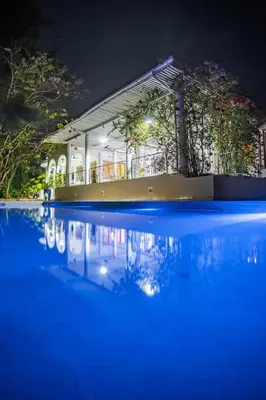 a building with a pool of water at night at The Kilimanjaro Villa in Moshi