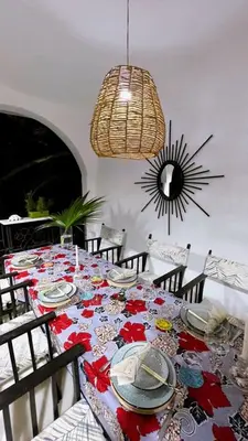 a dining room with a table with chairs and a chandelier at Kilimanjaro Twin Rooms Queen Beds in Moshi