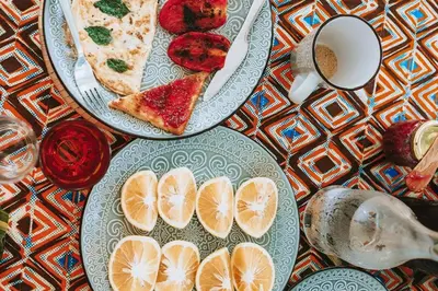 two plates with slices of pizza and a cup of coffee at Kilimanjaro Twin Rooms Queen Beds in Moshi