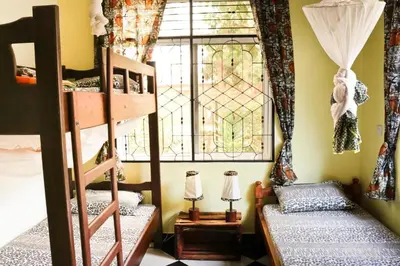 a room with two bunk beds and a window at BABA AFRICA HOSTEL in Arusha