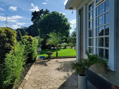 a porch of a house with a courtyard with trees at Romantic Getaway in Arusha