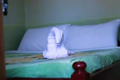 a bed with a pair of white boots on it at Bamboo Savannah in Arusha