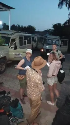 a group of people standing around in a parking lot at The Charity Hotel International in Arusha