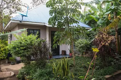 a small house surrounded by trees and plants at Mesa, Mama Ket Homes Arusha in Arusha