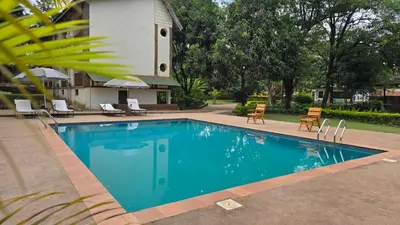 a swimming pool in front of a house at Kilimanjaro Lodge Cabins in Moshi