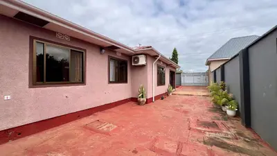 a pink house with a patio with plants at Ultra Home - Bed and Breakfast in Themi