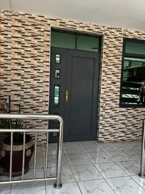 a black door on the side of a brick building at Hadraj Clocktower Apartment1 in Arusha