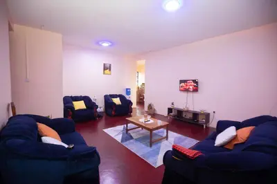 a living room with two blue couches and a table at New Star House in Arusha