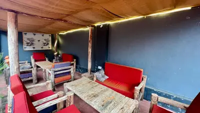 a room with chairs and a table and red chairs at Ultra Home Hostel in Arusha