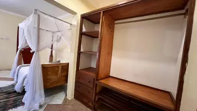 a bedroom with a canopy bed and a dresser at Ultra Home Hostel in Arusha