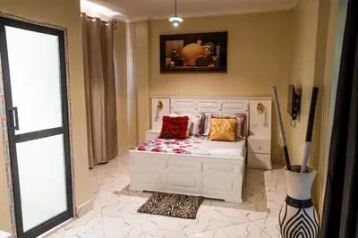 a bedroom with a white bed with pillows on it at Bienvenido a casa villa in Arusha