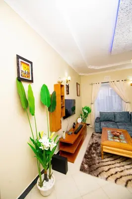 a living room with a blue couch and a table at Private Nest Apartment 2 in Arusha