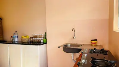 a small kitchen with a sink and a stove at Safari Roots Hostel in Arusha