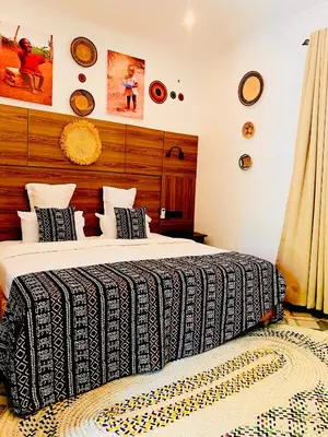 a bedroom with a bed with a black and white blanket at Sunset Retreat Hotel in Arusha