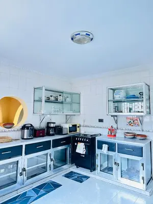 a large kitchen with blue cabinets and appliances at KL shadow Homes in Arusha