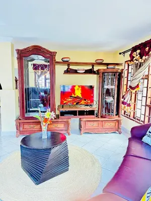 a living room with a couch and a tv at KL shadow Homes in Arusha