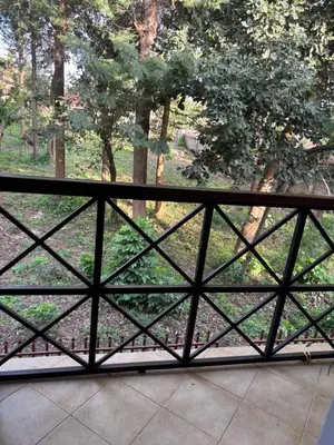 a fence with a view of a field with trees at Wimake homes in Arusha