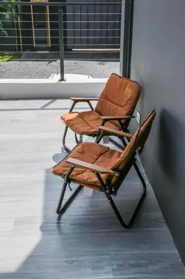 a brown chair sitting next to a wall at Rabi Residence - Two French units sleeps 4 in Arusha