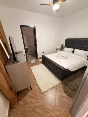 a bedroom with a bed and a flat screen tv at Royal Safary Appartement in Arusha