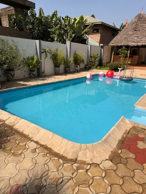 a large swimming pool with blue water in a yard at Royal Safary Appartement in Arusha